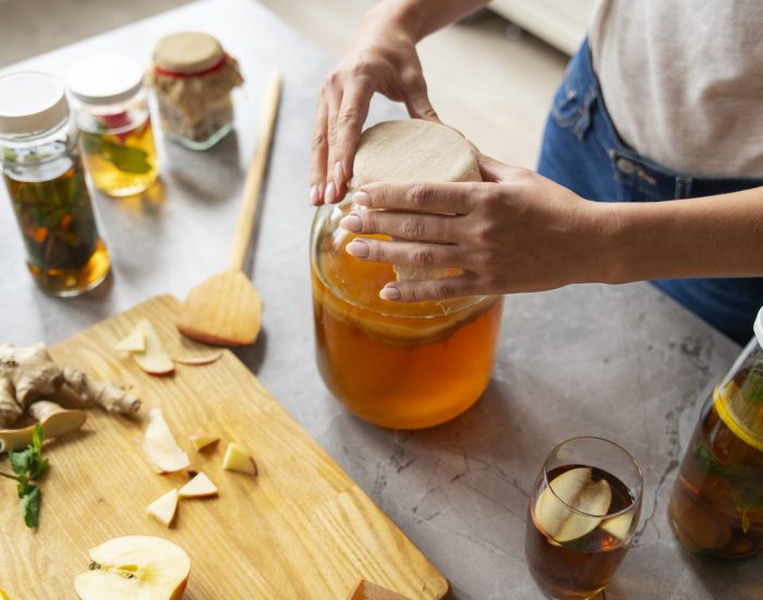 high-angle-woman-preparing-kombucha